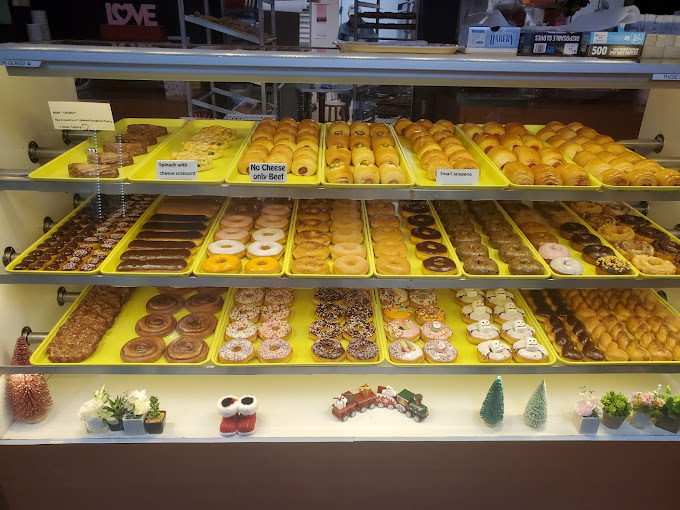 Full display case with rows of fresh donuts